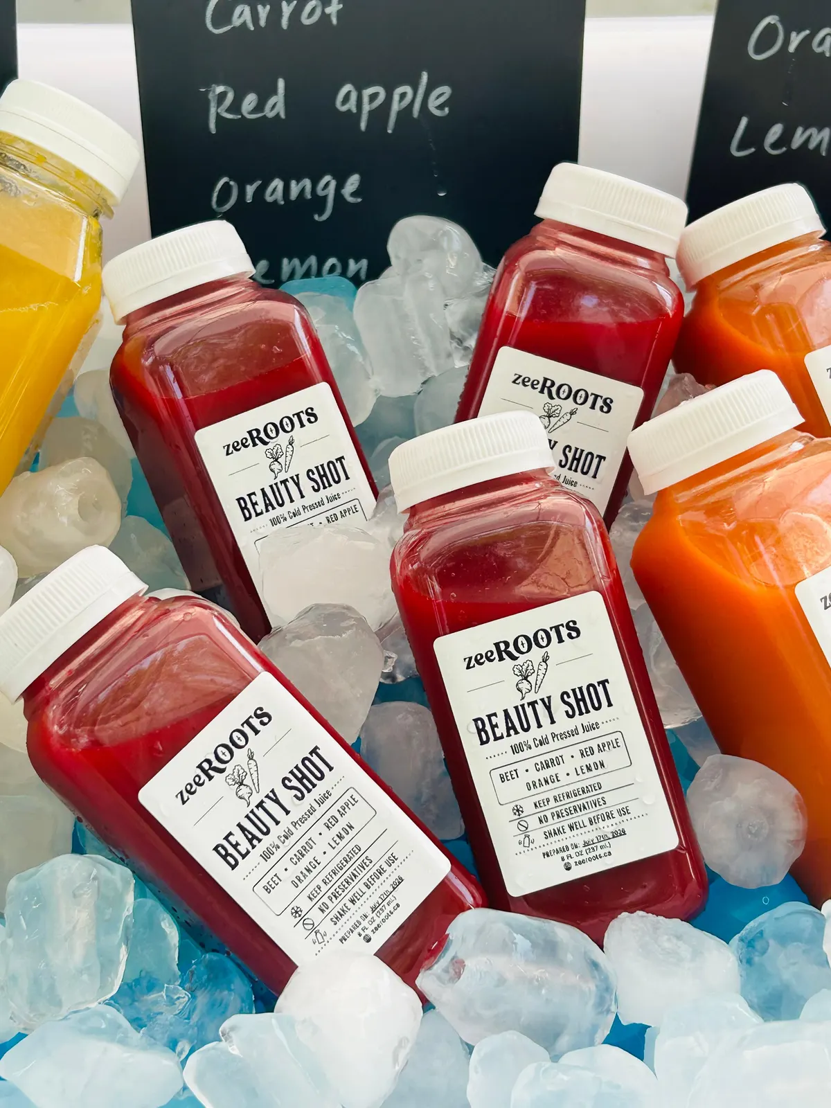zeeROOTS juice bottles arranged at a community market table